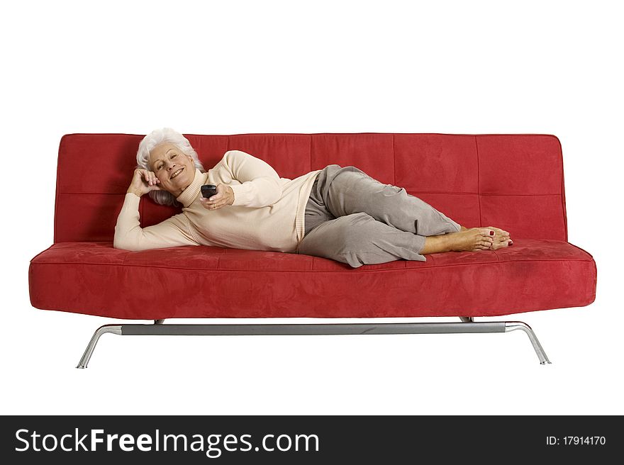 Elderly woman on the sofa with television remote control