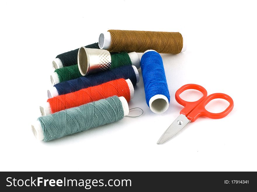 Colorful spools, scissors, and thimble isolated on white. Colorful spools, scissors, and thimble isolated on white