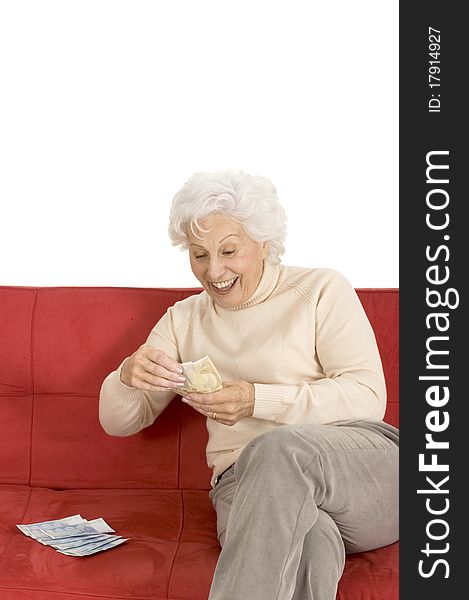 Elderly woman on the couch with money in hand in a white background