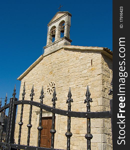 Village chapel against clear blue sky: wrought iron fence, church courtyard, wooden door and stone brick religious building

Location: Vizinada in Istria, Croatia, Europe

*RAW format available at request. Village chapel against clear blue sky: wrought iron fence, church courtyard, wooden door and stone brick religious building

Location: Vizinada in Istria, Croatia, Europe

*RAW format available at request