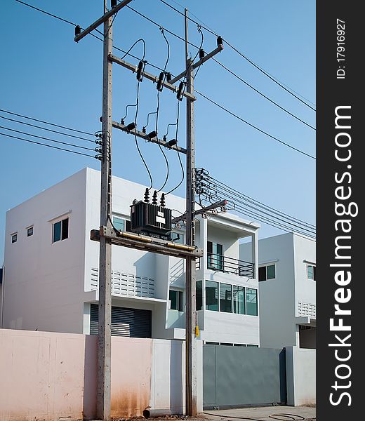 Electric poles and transformers. In front of new buildings