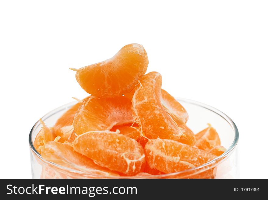 A sliced mandarin in the glass form on white