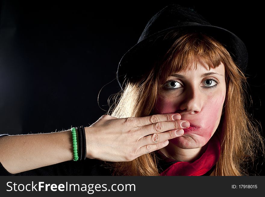 Blonde girl deforms the face with his own hands on black background