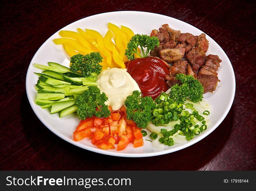 Appetizing meat and vegetable allsorts with sauces and greens