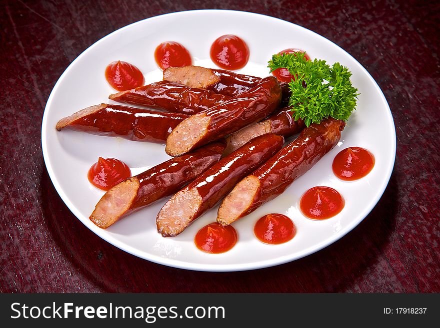 Appetizing Bavarian sausages with sauce and greens