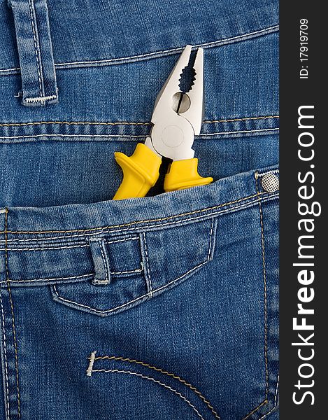 Yellow pliers in pocket jeans