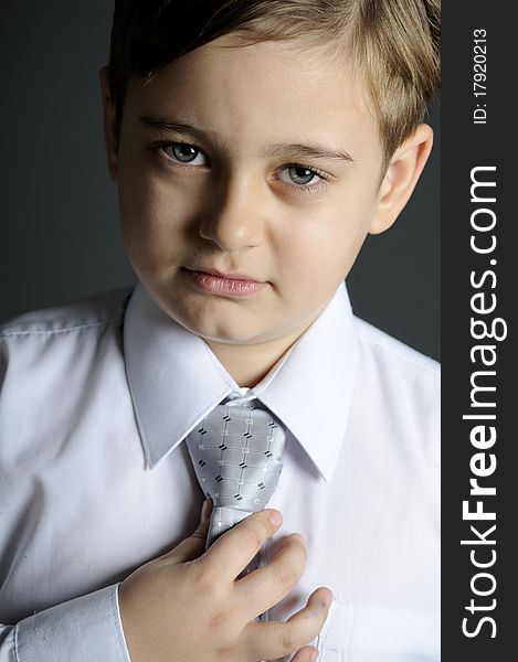 White cute boy arranging accessory in studio. White cute boy arranging accessory in studio