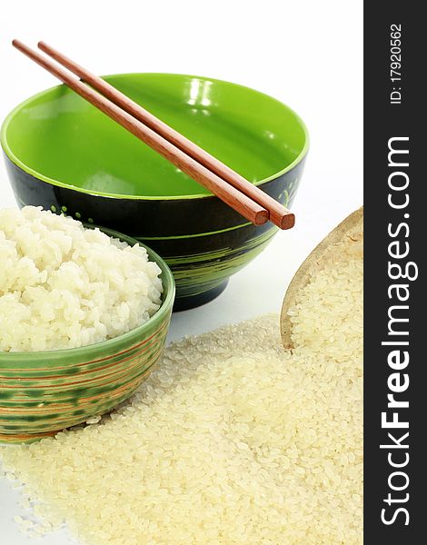 A bowl of rice and a pile of uncooked rice closeup