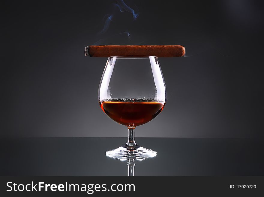 Glass of cognac with a cigar