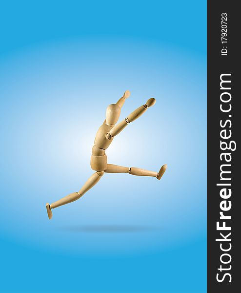 Wooden leaping figure on a blue background single object. Wooden leaping figure on a blue background single object.