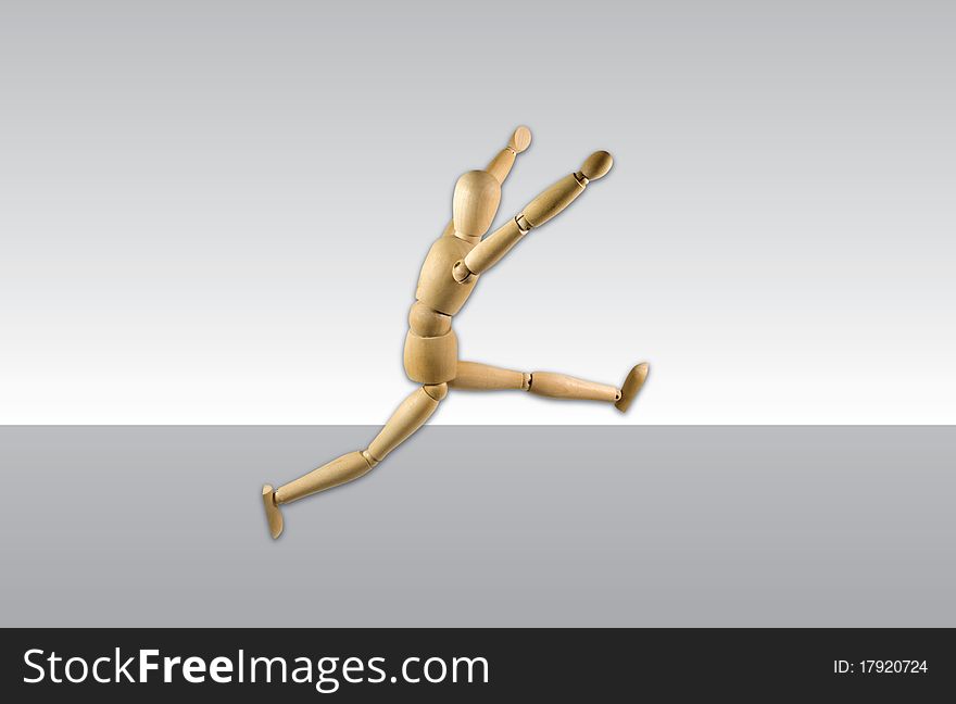 Wooden leaping figure on a gray background single object. Wooden leaping figure on a gray background single object.