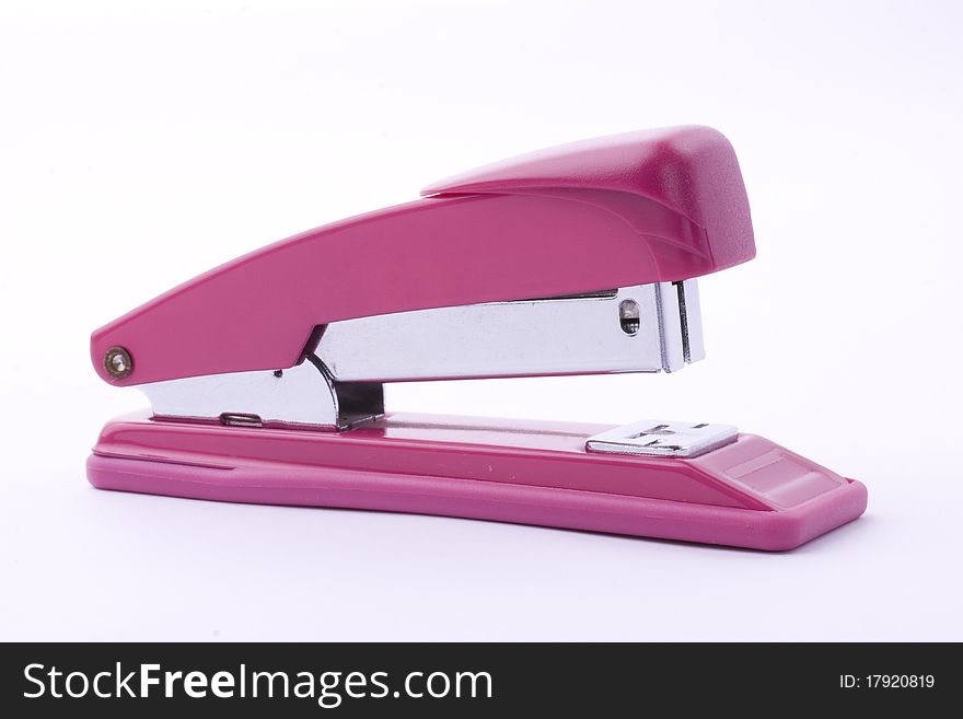 Small pink stapler with paper clips on a white background