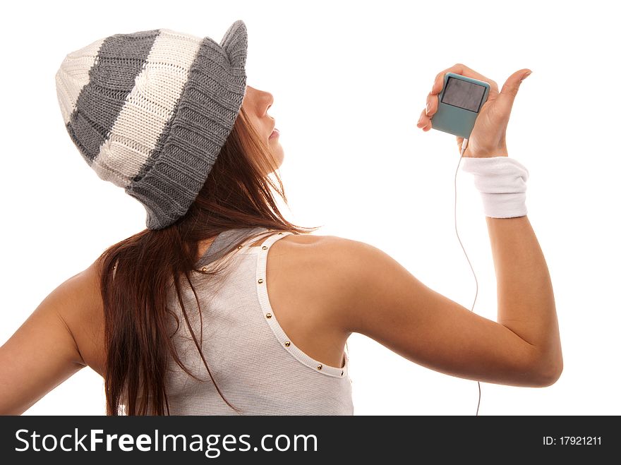 Girl listening to music on mp3 player in white headphones wearing hip-hop style hat and dance top isolated on white background. Girl listening to music on mp3 player in white headphones wearing hip-hop style hat and dance top isolated on white background