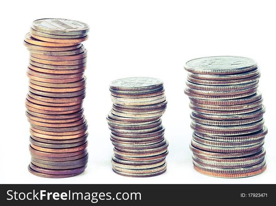 Three piles of coins across white