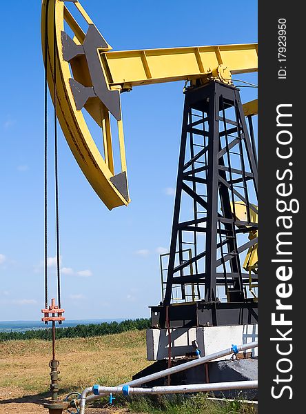 Oilfield Pump Jack with a bright blue sky and clouds. Oilfield Pump Jack with a bright blue sky and clouds