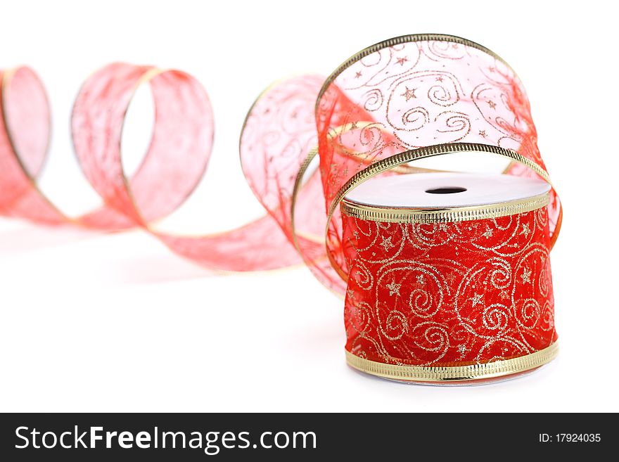 Roll of red ribbon with gold trim isolated on white background