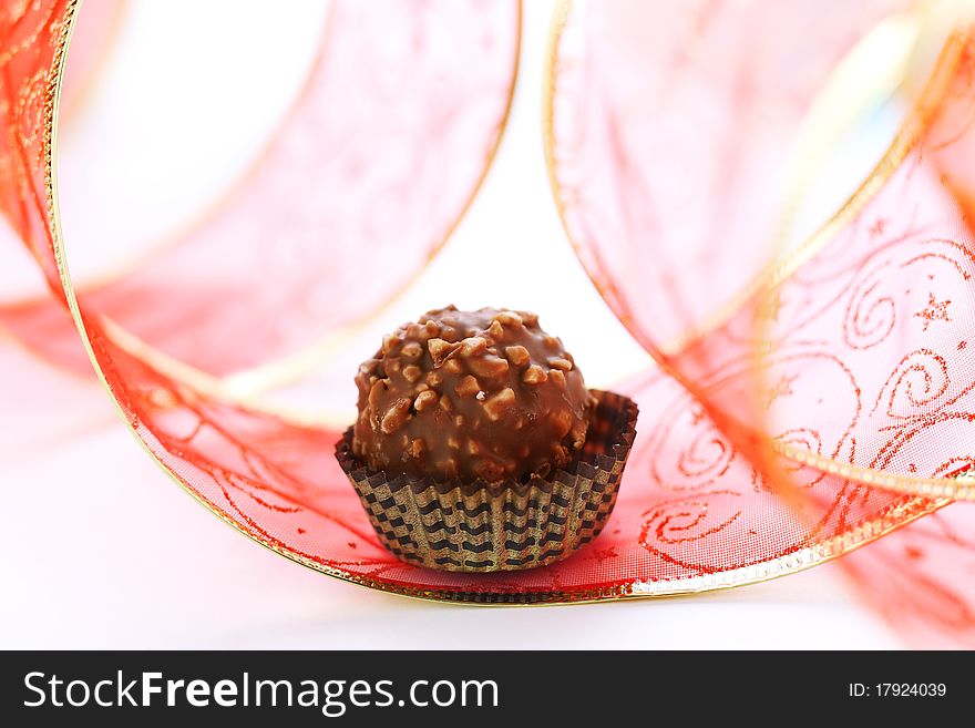 Chocolate truffle with red ribbon closeup
