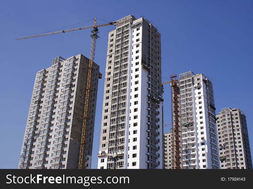 HIGH-RISE UNDER CONSTRUCTION IN BLUE SKY. HIGH-RISE UNDER CONSTRUCTION IN BLUE SKY