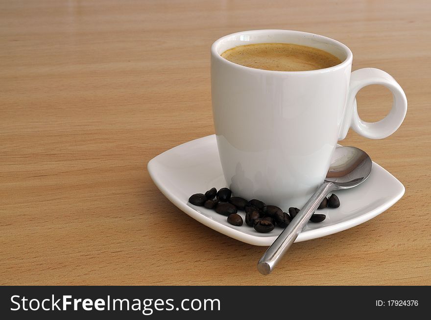 A Drink of Coffee in Cup and Saucer with coffee beans