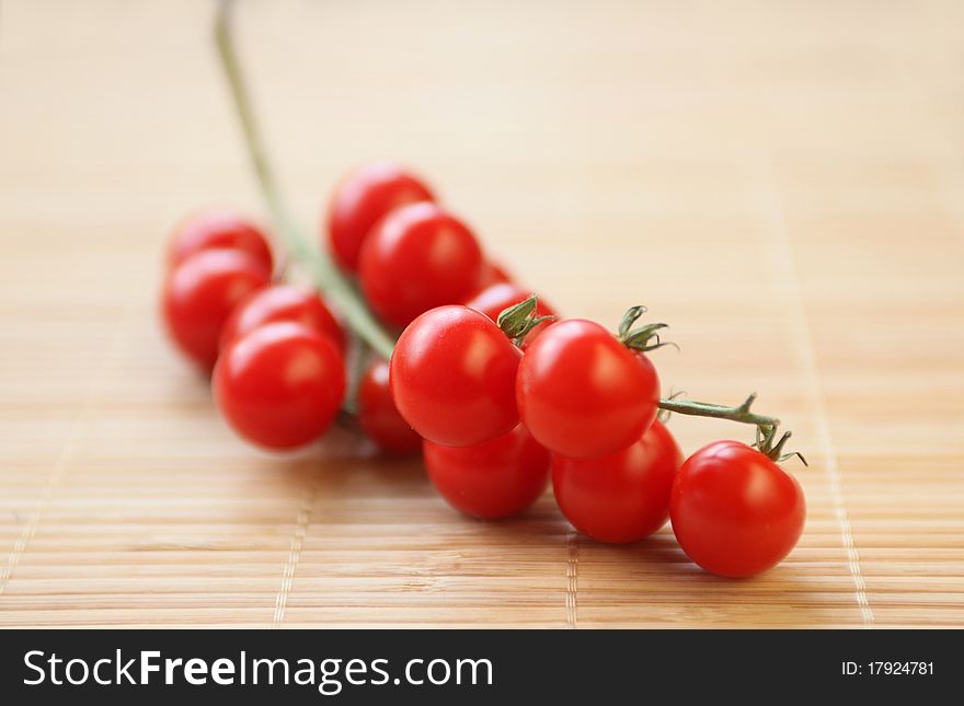 Branch or cherry tomatoes on wooden pad