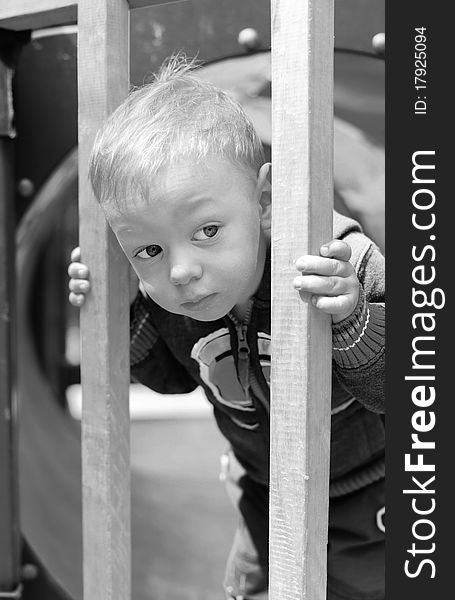 Little kid looking at something on playground. Little kid looking at something on playground