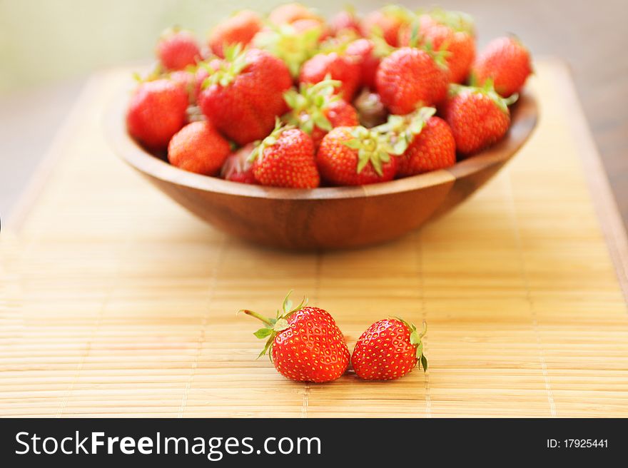 Fresh ripe strawberries in wooden bowl