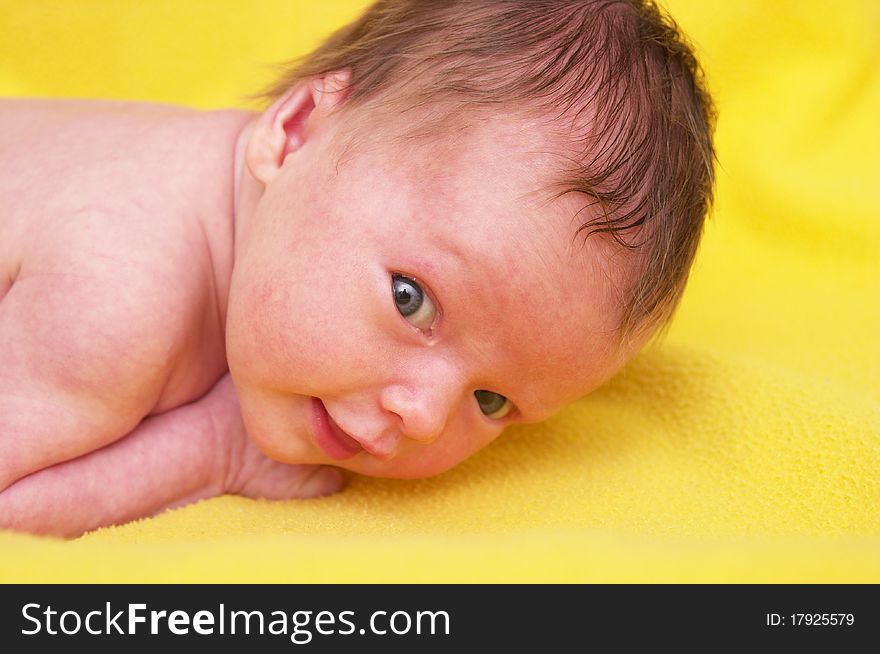 Newborn baby girl over soft yellow towel