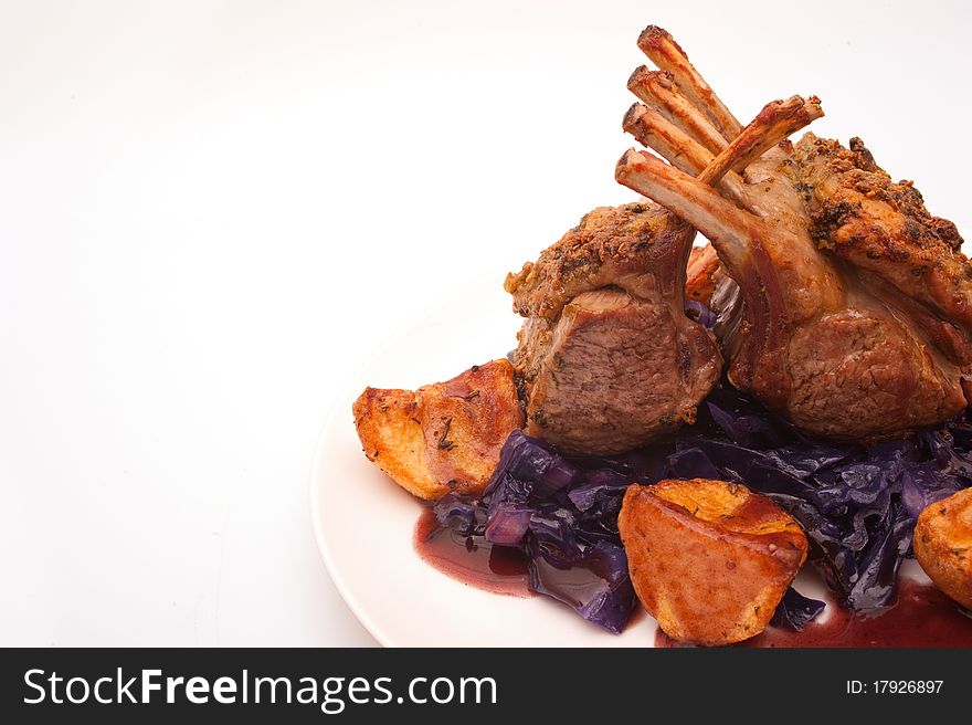 French dressed rack of lamb plated with potatoes and red cabbage. French dressed rack of lamb plated with potatoes and red cabbage