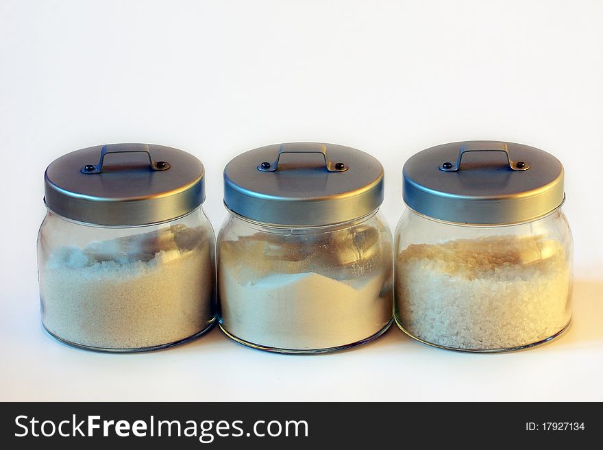 Three jars of sugar and salt with white background