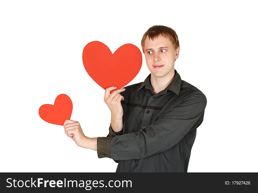 Young caucasian man holding red paper hearts and looking on it isolated