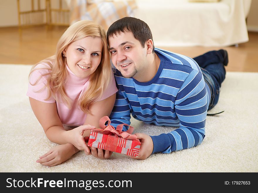 Young beautiful couple together with a present. Young beautiful couple together with a present
