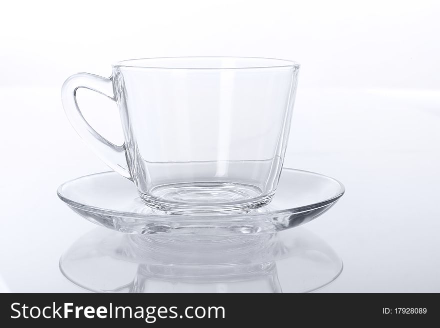 Empty transparent glass cup and saucer.