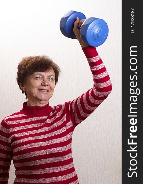 Senior active model with a dumb-bell in the hand. Senior active model with a dumb-bell in the hand