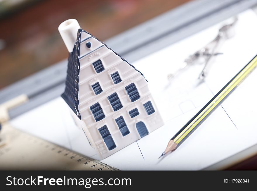 Breadboard model of a house and paper with a pencil