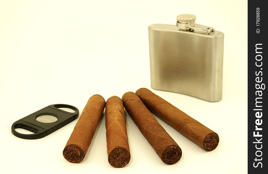 Close up of  4 cigars, cigar cutter and hip flask. Close up of  4 cigars, cigar cutter and hip flask