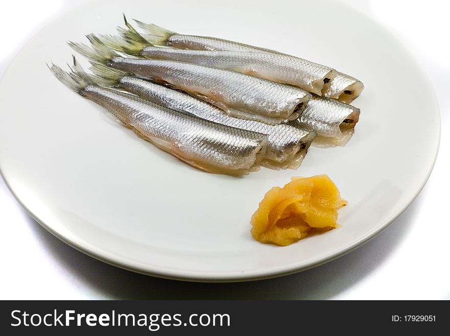 Freh small scale fish with caviar on white plate