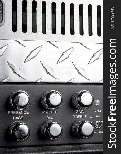 Black and metallic guitar apmlifier panel with metallic shiny knobs for bass treble and middle control. Black and metallic guitar apmlifier panel with metallic shiny knobs for bass treble and middle control