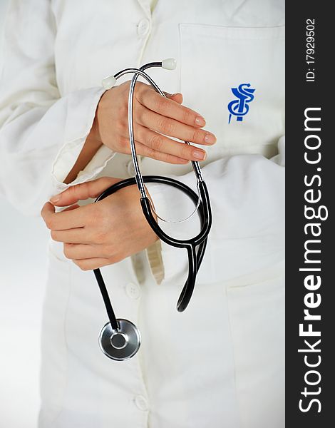 Nurse standing and holding her stethoscope in her hands. Nurse standing and holding her stethoscope in her hands