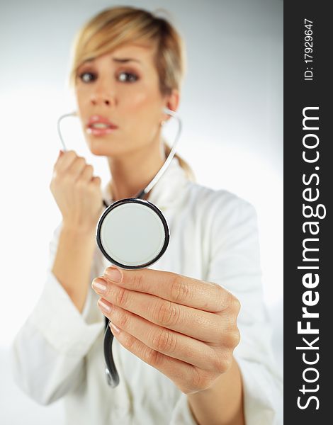 Nurse with the stethoscope in her hand looking worried. Nurse with the stethoscope in her hand looking worried