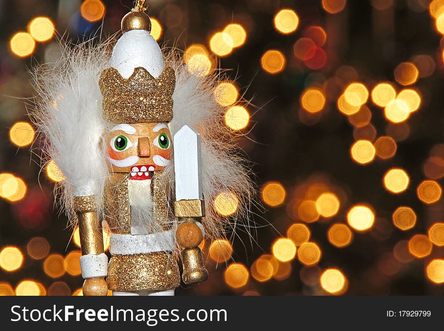 Christmas holiday ornament figurine in the foreground and Christmas tree lights (bokeh) in the background. Christmas holiday ornament figurine in the foreground and Christmas tree lights (bokeh) in the background