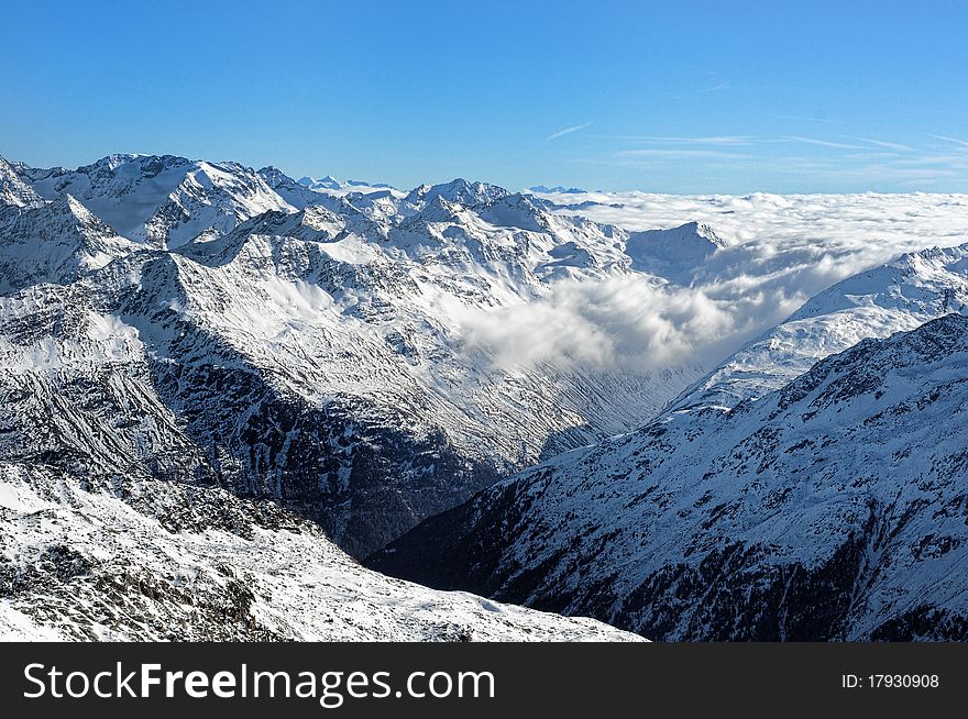 Austrian alpine valley covered by sea of clouds.