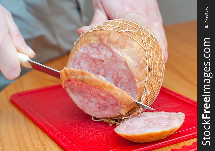 Round ham in a grid on the board and knife