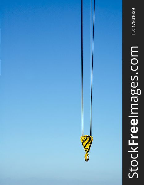 Hook from crane against blue sky. Hook from crane against blue sky