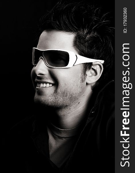 Attractive male wearing sunglasses against black background