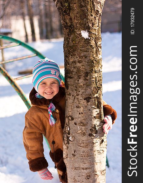 Beautiful Girl Playing Near The Tree In Winter