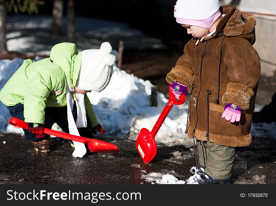 Children playing with spades outdoor in winter. Children playing with spades outdoor in winter