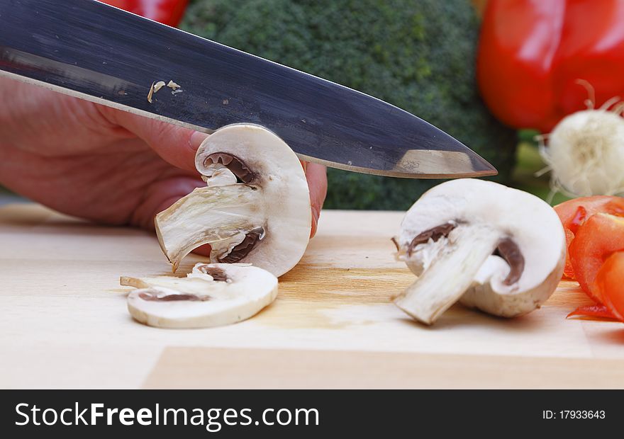 Detail of a knife cutting mushrooms. Detail of a knife cutting mushrooms.