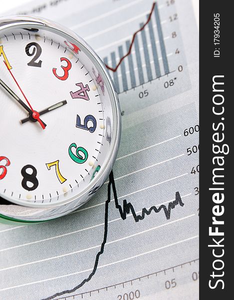 A clock and business or stock chart, shown as business trend and time, or stock market benefit related with time. A clock and business or stock chart, shown as business trend and time, or stock market benefit related with time.