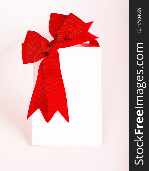 Beautiful red bow over blank greeting card, holiday concept. Beautiful red bow over blank greeting card, holiday concept