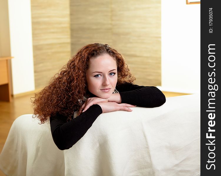 A young red hair girl sitting on the sofa at home alone. A young red hair girl sitting on the sofa at home alone